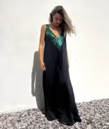 Vestido largo de corte holgado en color negro, con escote en V profundo decorado con apliques de lentejuelas en color verde esmeralda.