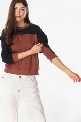 Buzo de algodón con elastano, diseño en bloques de color marrón y negro, cuello redondo y mangas largas.
