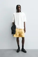 Bermuda de algodón gris con efecto lavado, corte relajado, cintura elástica ajustable con cordón y bolsillos laterales y trasero de vivo.