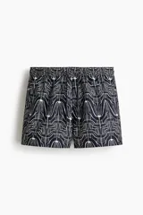 Short de baño azul marino con estampado geométrico abstracto en color blanco, cintura elástica con cordón ajustable y bolsillos laterales.