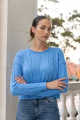 Sweater celeste de punto con trenzas verticales en el frente y en las mangas.