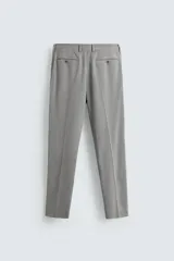 Pantalón de traje corte slim fit, color azul marino con textura sutil. Cuenta con bolsillos laterales, bolsillos traseros con botón y cierre frontal con cremallera y botón.