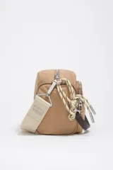 Bolso tipo morral Bimba y Lola, de color tostado, confeccionado en nylon suave con detalles en cuero y tirantes de cordón. Cuenta con múltiples compartimentos con cierre y el logo metálico de la marca en el frente.