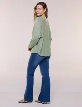 Buzo tejido liviano de calce holgado color celeste, con escote bote y mangas tipo dolman.