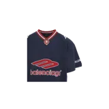 Remera Balenciaga estilo camiseta de fútbol oversize, color azul marino con cuello en V de rayas rojas y blancas, escudos y logotipos impresos en el pecho y las mangas.
