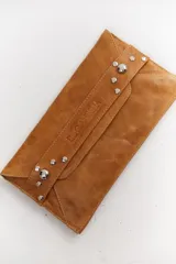 Sobre de cuero negro con solapa, cierre magnético y muñequera con tachas plateadas.