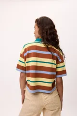 Remera tejida de algodón con cuello polo amarillo, corte boxy y estampado de rayas horizontales en tonos azul claro, marrón, rojo y amarillo.