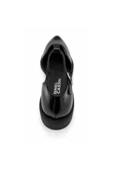 Zapato chatita de Daniel Cassin color negro con acabado brillante, diseño en punta, tira en T y tira ajustable con hebilla al tobillo.