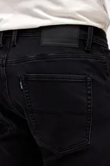 Jean de corte slim, color negro, con diseño de cinco bolsillos, cierre frontal con botón y cremallera.