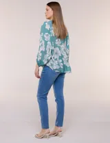 Blusa holgada de gasa texturizada color blanco con estampado de lunares negros, escote en V con botones frontales, mangas 3/4 abullonadas y puños elásticos.
