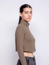 Top negro de manga larga con cuello alto y cierre frontal.