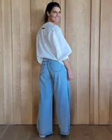 Pantalón de jean estilo wide leg con costuras verticales frontales, tiro alto y bolsillos laterales.