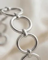 Pulsera tipo esclava de acero con diseño de eslabones circulares entrelazados.