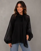 Camisa negra de gasa con diseño plisado vertical en el cuerpo. Presenta cuello alto con corbatín integrado, mangas largas abullonadas con puños ajustados y corte holgado.