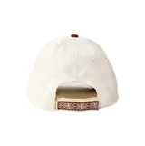Gorra de visera curva confeccionada en pana, con cuerpo en color beige y visera en color marrón. Presenta un parche frontal con el logo de la marca en tonos rosados y marrones.