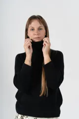 Sweater gris de tejido de punto, con cuello alto y mangas largas.