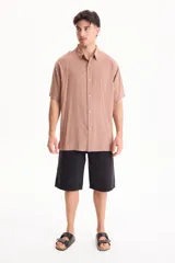 Camisa de viscosa negra de manga corta, con cuello camisero y cierre frontal de botones, de corte oversize.