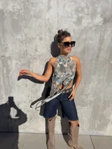 Top halter estampado con diseño animal print combinado en tonos celestes, marrones y negros, con cuello alto y paneles delanteros largos y cruzados.