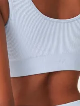 Top deportivo de tejido acanalado sin costuras, con escote redondo y diseño de espalda estilo nadadora. Ofrece un ajuste ceñido y soporte medio.