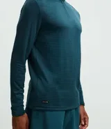 Remera deportiva de manga larga con cuello alto y cierre frontal parcial. Presenta una textura acanalada en toda la prenda y detalles reflectivos en los hombros.