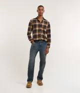 Camisa de franela para hombre, modelo comfort, con estampado de cuadros en tonos azules, blancos y negros, cuello camisero, manga larga y cierre frontal de botones.