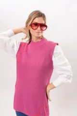 Chaleco tejido de punto fucsia con cuello alto y ribete de contraste color naranja.