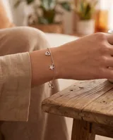 Pulsera de cadena plateada con dijes colgantes de corazón y estrella con incrustaciones de circones.