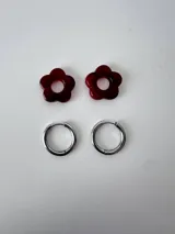 Aros de acero quirúrgico argolla con dije colgante en forma de flor de resina color gris marmoleado.