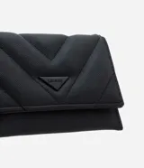 Billetera pequeña tipo sobre marca Satinato, confeccionada en poliuretano con acabado acolchado y textura granulada. Presenta un diseño geométrico con costuras en forma de V y un aplique metálico triangular con el logo de la marca en el frente. Cuenta con cierre a presión.