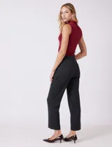 Pantalón de vestir de corte recto y tiro medio-alto, confeccionado en tela sastrera. Presenta cierre frontal con botón, presillas para cinturón y detalles de botones decorativos en carey en la cintura. Incluye bolsillos laterales funcionales y pinzas traseras para un ajuste estilizado.