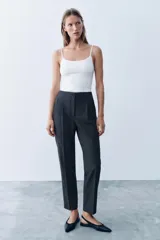Pantalón de tiro alto y corte slim fit, color azul marino con diseño de rayas diplomáticas. Es de largo tobillero, cuenta con bolsillos delanteros de vivo y costuras marcadas en el delantero y la espalda. Cierre frontal con cremallera, botón interior y gancho metálico.