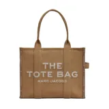 Cartera The Large Tote de Marc Jacobs en color tostado, con diseño estructurado y asas superiores resistentes. Cuenta con el estampado característico 'THE TOTE BAG MARC JACOBS' en la parte frontal y un amplio compartimento interior.