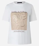 Remera blanca de algodón con estampado rectangular frontal con el texto "Jardin du Village" y un dibujo de una flor.