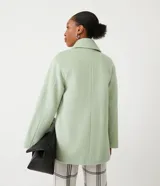 Saco cruzado de mujer color verde menta, con cuello solapa y manga larga. Presenta bolsillos frontales con solapa y cierre de botón.