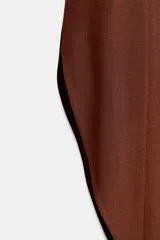Falda midi de tiro medio color beige, con cintura elástica en la espalda y diseño asimétrico con aberturas laterales.