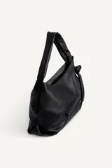 Bolso tipo shopper de hombro confeccionado en piel de alta calidad, con diseño minimalista y cierre principal mediante cremallera. Cuenta con un bolsillo interior con cierre y asa ajustable.