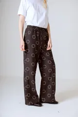 Pantalón de vestir negro con estampado de círculos blancos, corte holgado y tiro alto.