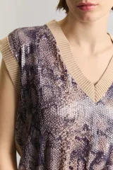 Chaleco sin mangas de viscosa, con escote en V y largo a la cintura. El frente cuenta con un panel de lentejuelas con estampado animal print de serpiente, mientras que la espalda y los bordes son de tejido liso en color tostado.