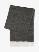 Bufanda de tejido suave en color gris oscuro jaspeado, con diseño rectangular y flecos decorativos en color blanco en los extremos.