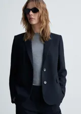 Chaqueta de corte recto y diseño estructurado con estampado de raya diplomática. Presenta cuello con solapa, cierre frontal de dos botones, manga larga con puños abotonados, un bolsillo de ribete en el pecho y dos bolsillos laterales con solapa.