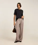 Blusa de manga corta confeccionada en algodón pima, con cuello redondo y diseño liso. Presenta un corte clásico con el bajo ligeramente más largo en la parte posterior.