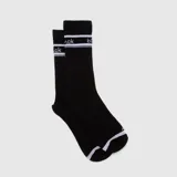 Medias de caña alta color negro con detalles de rayas blancas y la palabra 'black' estampada en la parte superior. Incluyen detalles en blanco en la puntera.