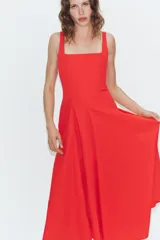 Vestido midi de popelín confeccionado en algodón, color marrón, con escote cuadrado, tirantes anchos y diseño acampanado con paneles godets. Cuenta con cierre lateral de cremallera oculta.