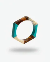 Pulsera rígida de forma hexagonal confeccionada en resina, con secciones en colores rojo, ámbar y efecto mármol blanco.