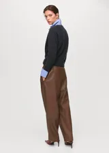 Pantalón efecto piel de color marrón, con diseño recto, tiro medio y cintura elástica con cordón ajustable. Cuenta con dos bolsillos laterales.