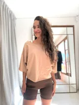 Remera corta de manga corta color celeste, con escote amplio en la espalda que se anuda en la parte inferior, dejando ver un top deportivo amarillo con tiras cruzadas.