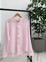Camisa de lino con diseño de rayas verticales en tonos rosado y blanco, cuello mao y cierre frontal con botones.
