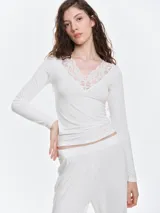 Remera de dormir de viscosa con escote en V y detalle de encaje floral en el escote. De manga larga y calce entallado.