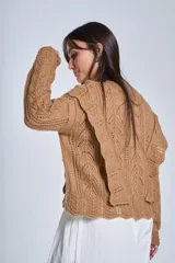 Sweater color camel de tejido calado con volados laterales y mangas largas.