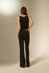 Pantalón tipo calza de tiro alto con corte flare, confeccionado en tejido de viscosa y elastano con detalles de strass dispersos.